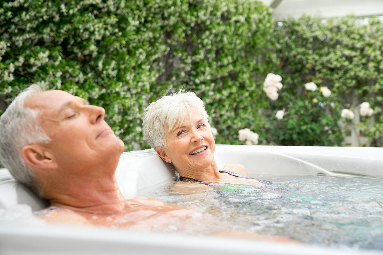 Couple relaxing in a Caldera Paradise Kauai hot tub outdoors