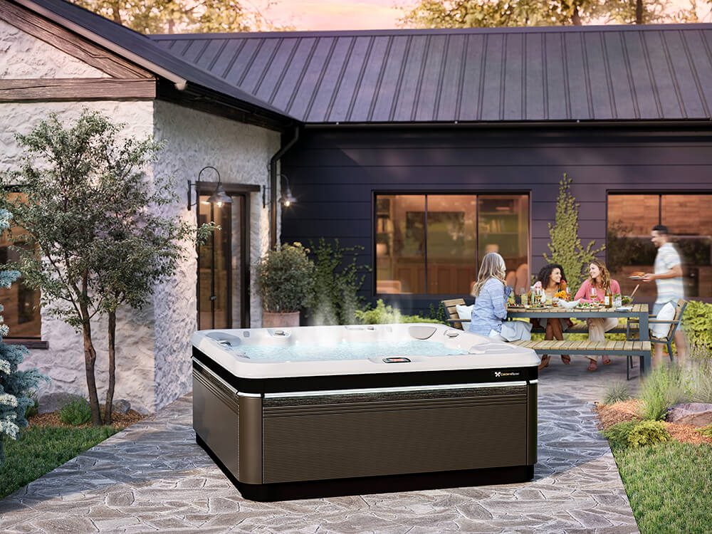 caldera-spas-utopia-series-a-spot-geneva-java-arctic-white-lifestyle-sunset-group-behind-spa